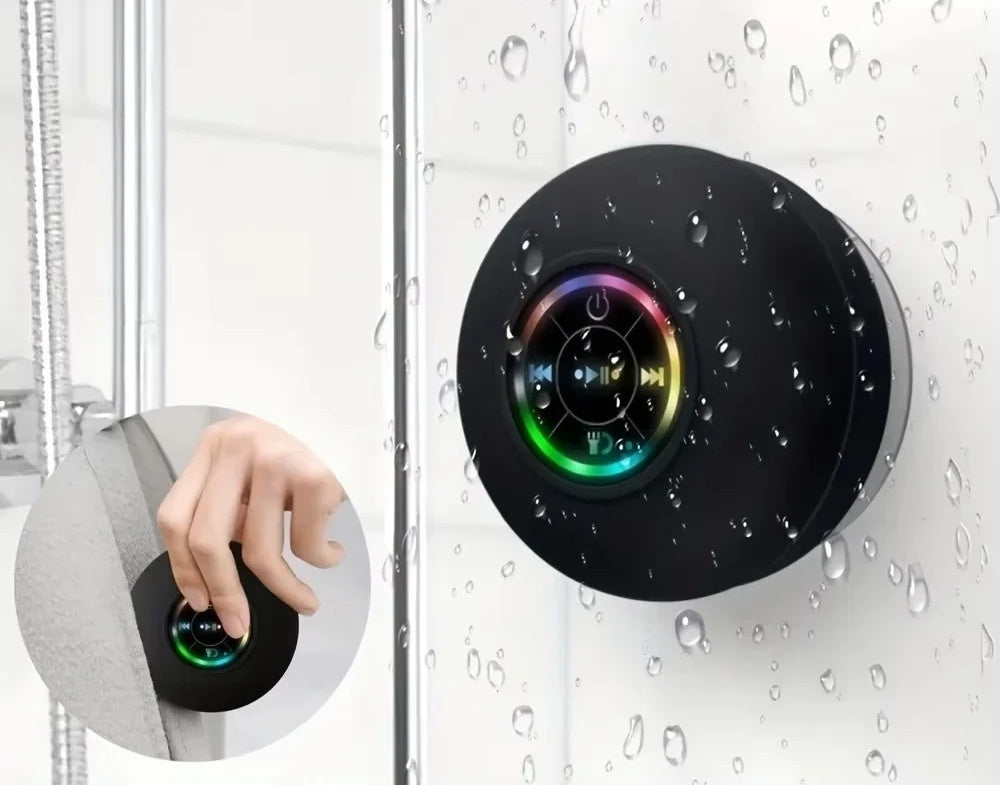 Mini parlante bluetooth negro adherido a la mampara de la ducha con gotas de agua